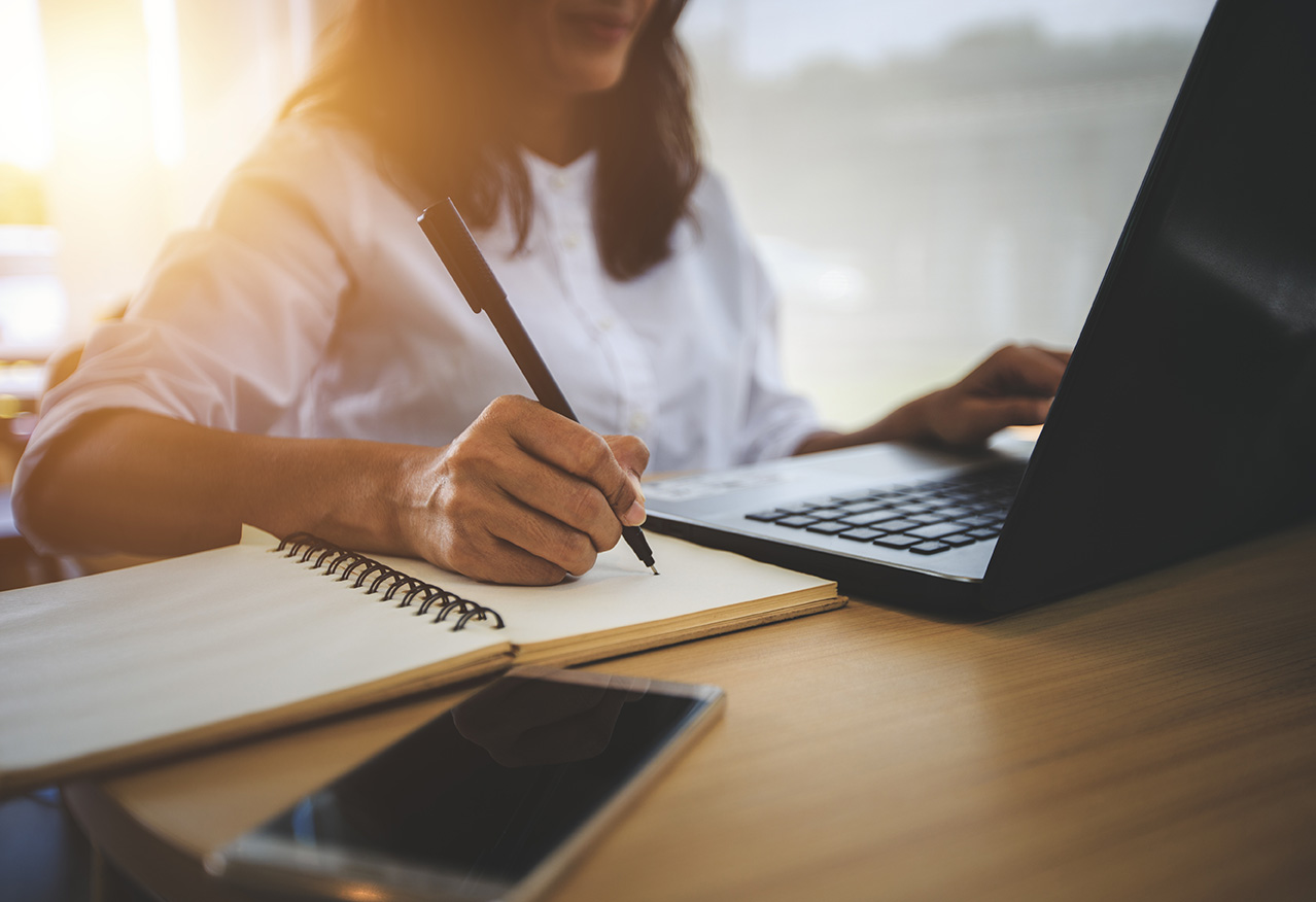 Woman writing on a notepad.