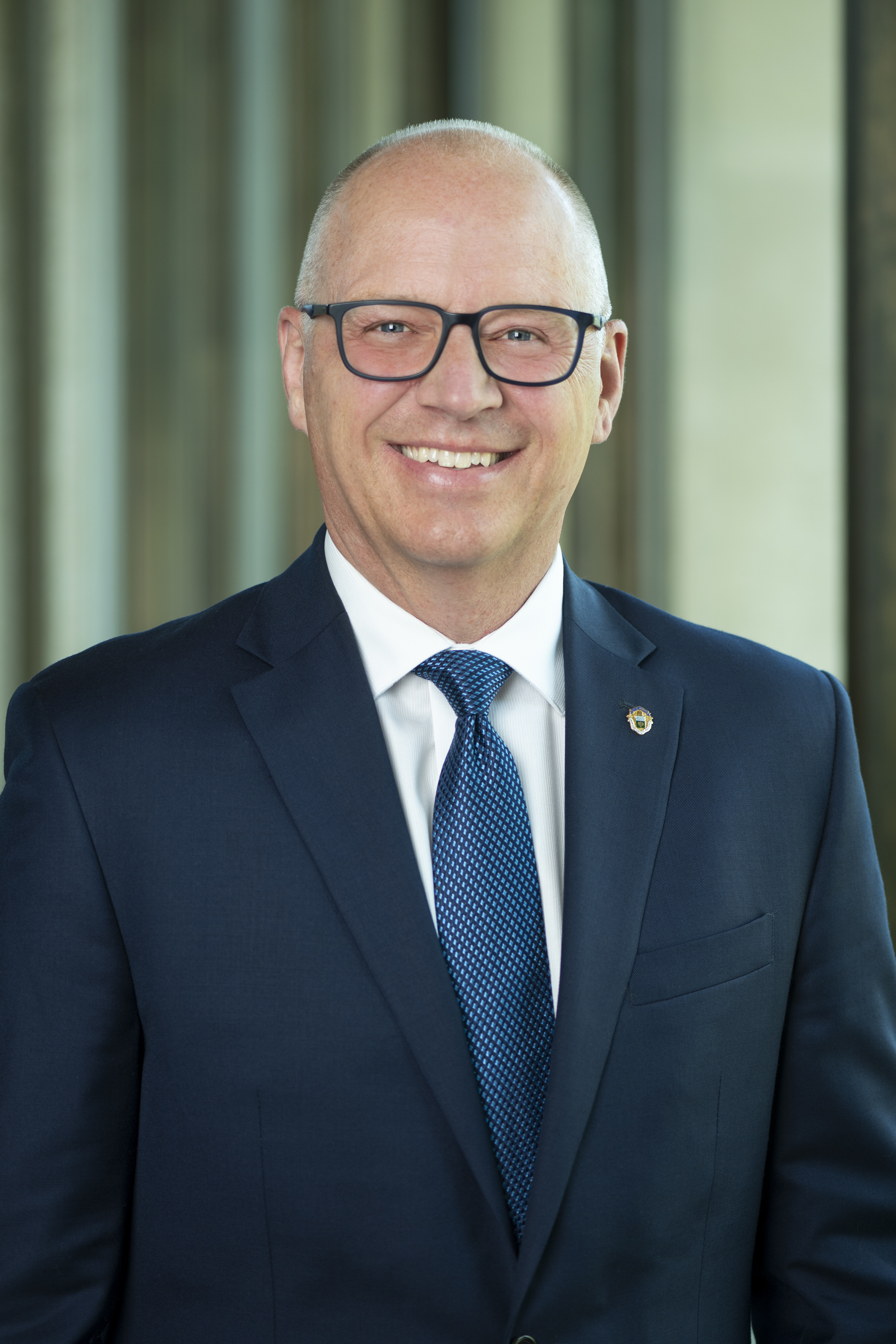 Winnipeg Mayor Scott Gillingham in a blue suit and tie wearing dark framed glasses.