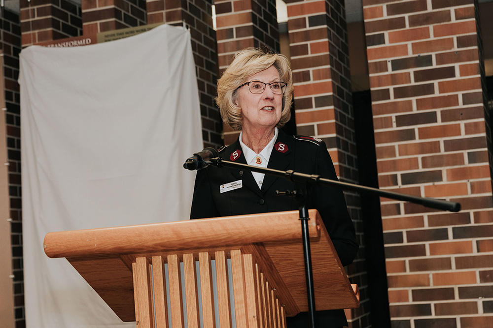Susan speaking at a podium.