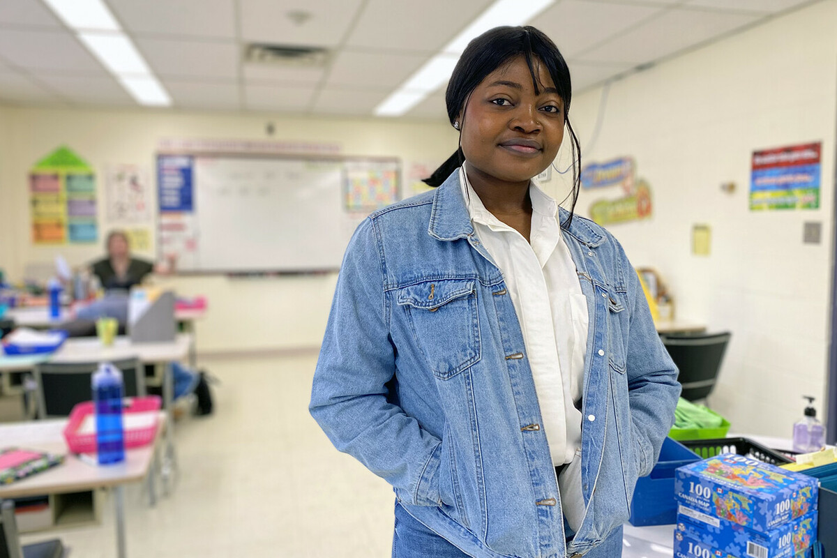 A woman stands in a classroom at a local organization.