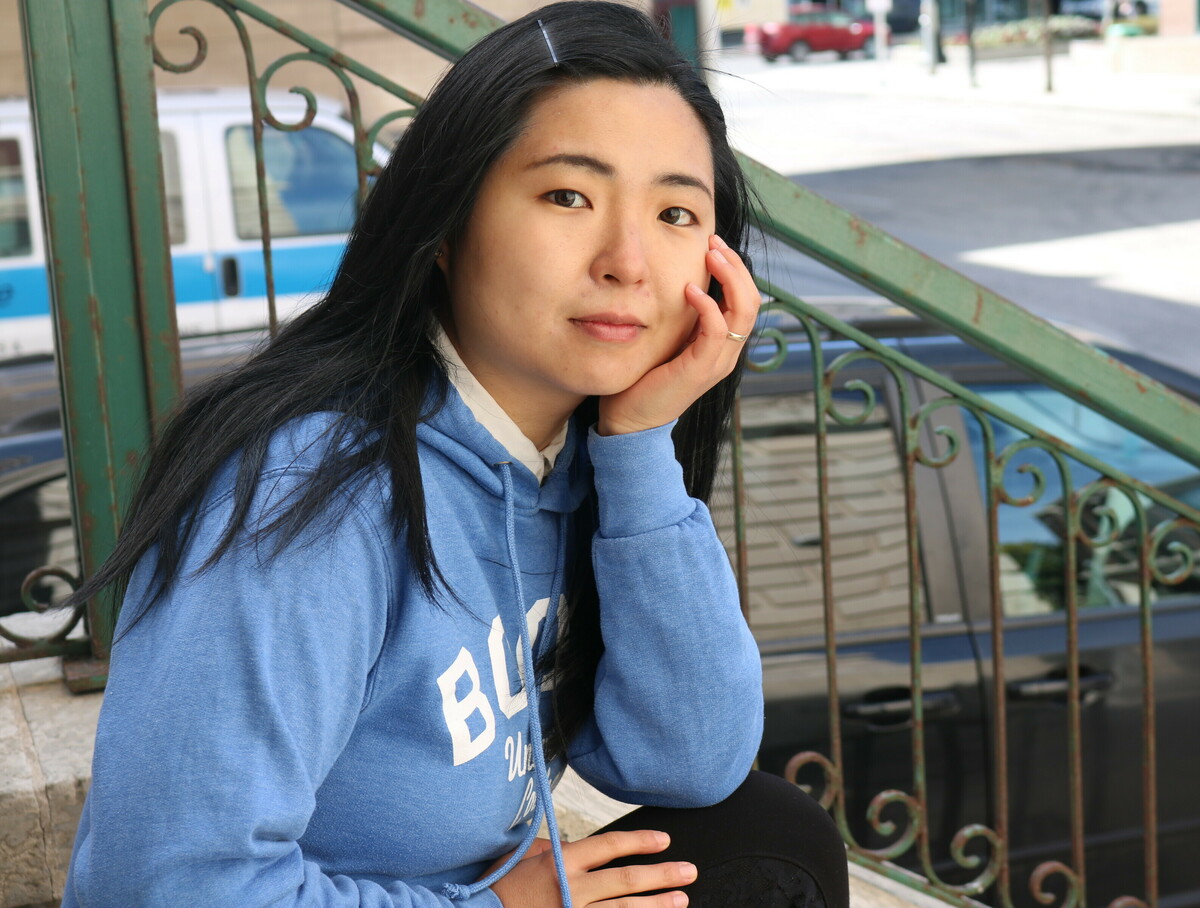 Catherine sitting on steps with her head resting on her hand.